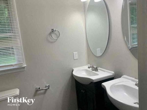 a white bathroom with two sinks and a mirror