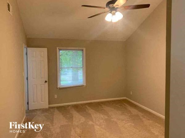 a empty bedroom with a ceiling fan and a window