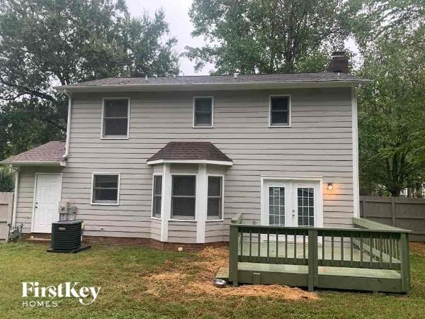 a white house with a wooden deck in a yard