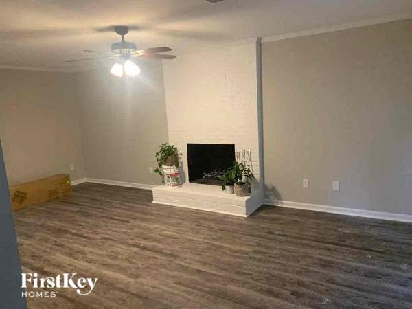 a living room with a fireplace and a ceiling fan