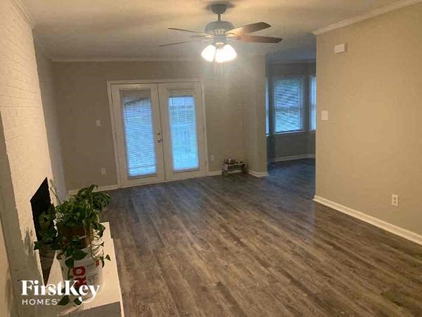 an empty living room with a ceiling fan