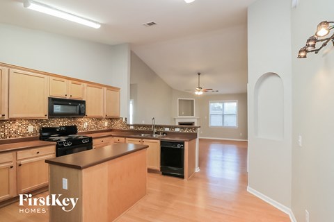 an open kitchen with wooden cabinets and a large counter top
