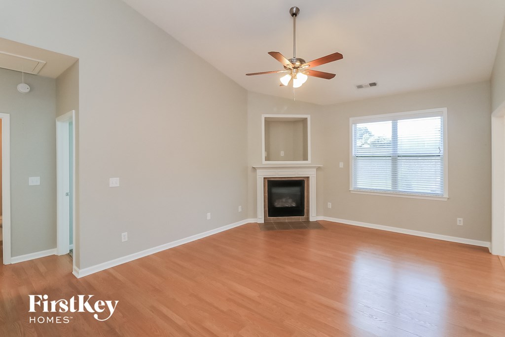 a living room with a fireplace and a ceiling fan