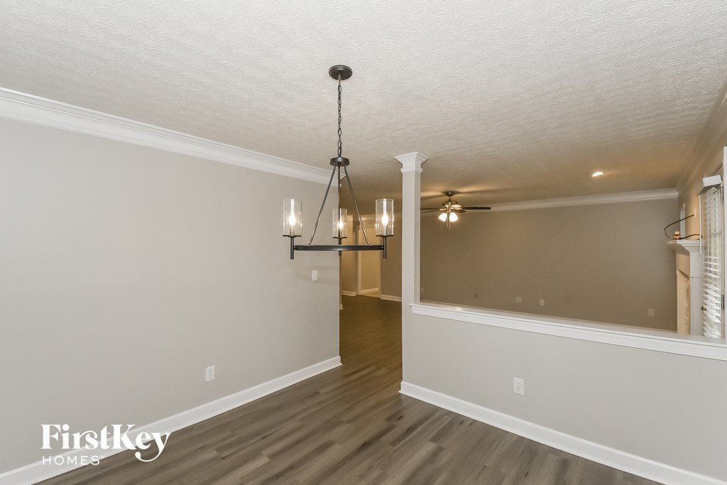 A room with a light fixture hanging from the ceiling and a door in the middle.