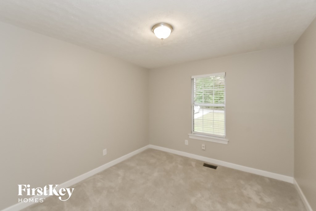 A room with a window and a light on the ceiling.