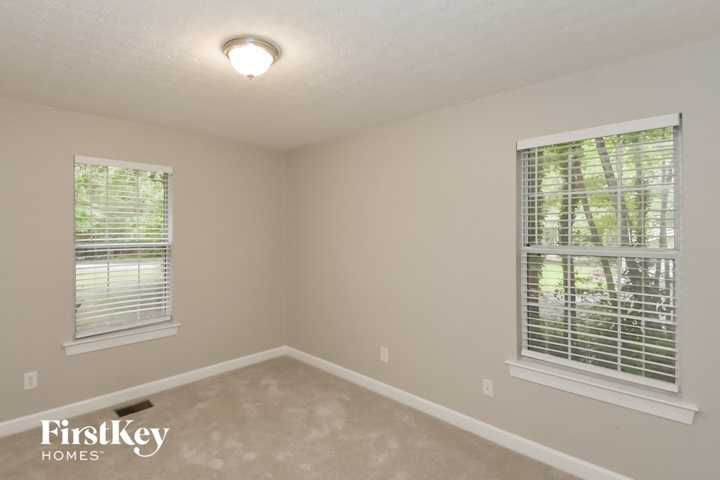 A room with a FirstKey Homes logo on the bottom left corner.