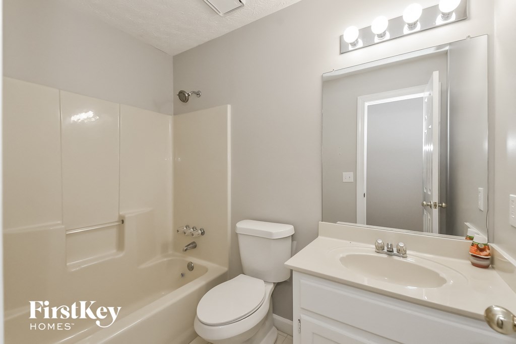 A white bathroom with a toilet, sink, and bathtub.