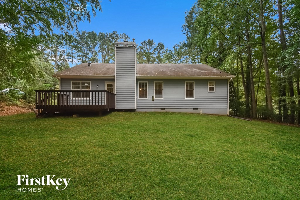 A house with a well-kept lawn and trees in the background.