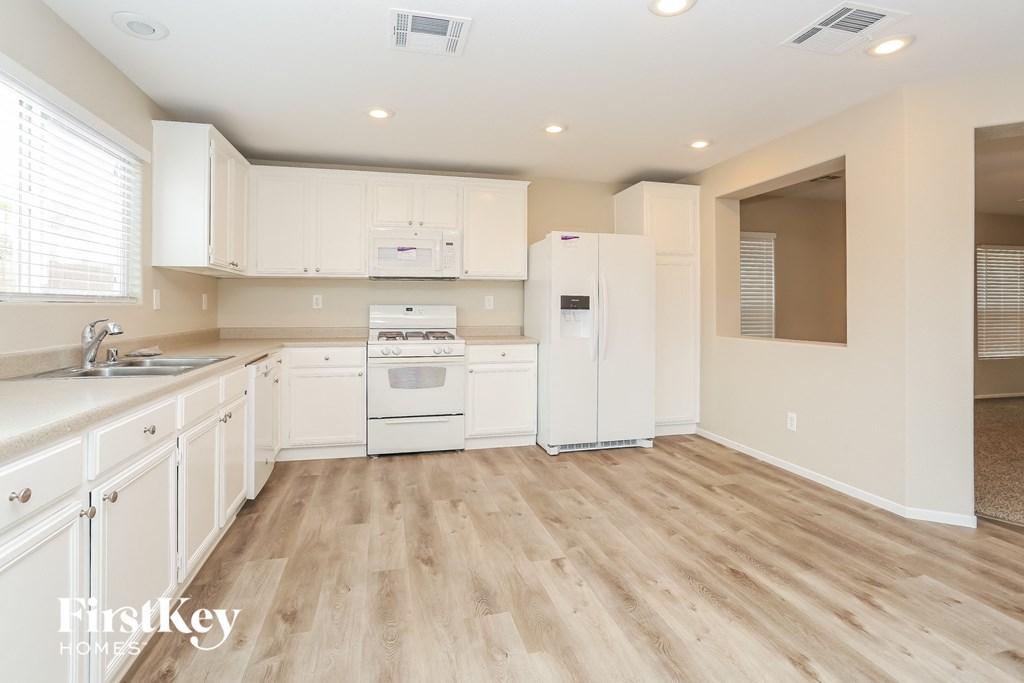 A kitchen with white cabinets and appliances.