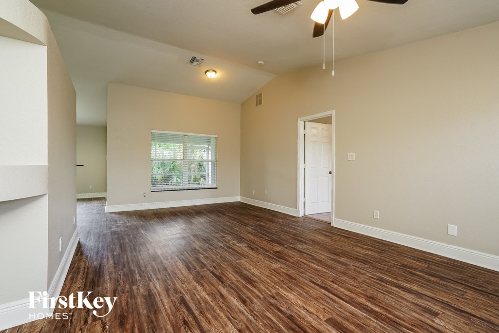 A room with wooden floors and a ceiling fan.
