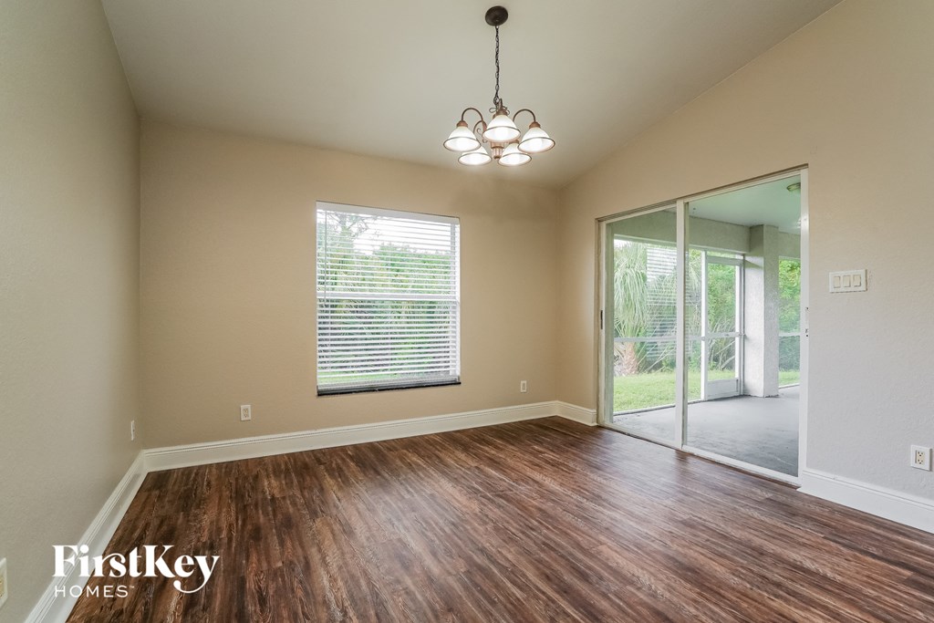 A room with wooden floors and a chandelier hanging from the ceiling.