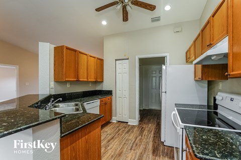 A kitchen with wooden cabinets and a black granite countertop.