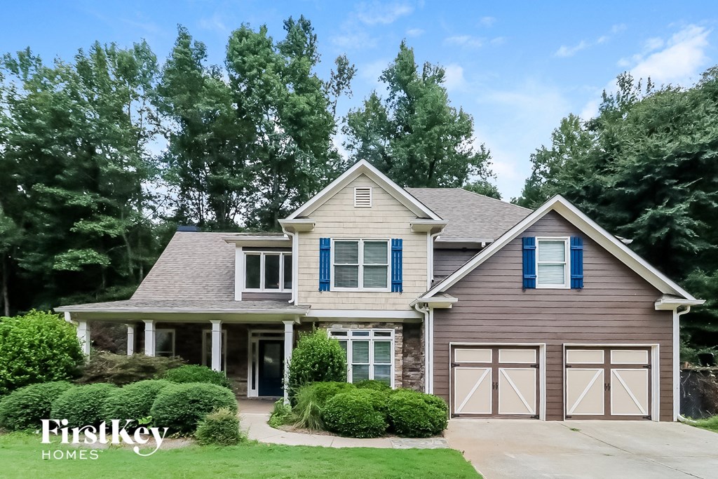 a house with blue shutters and white garage doors