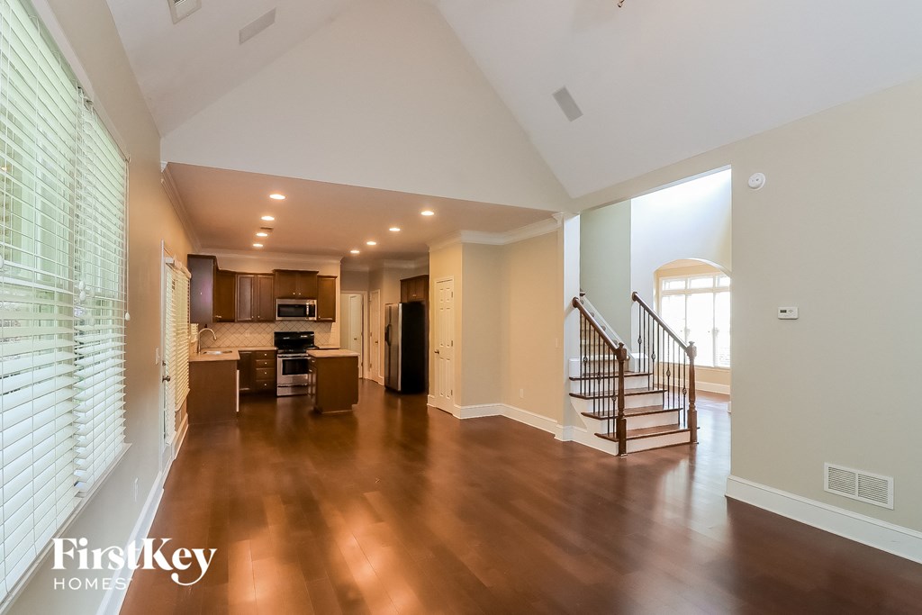 a large living room with a staircase and a kitchen