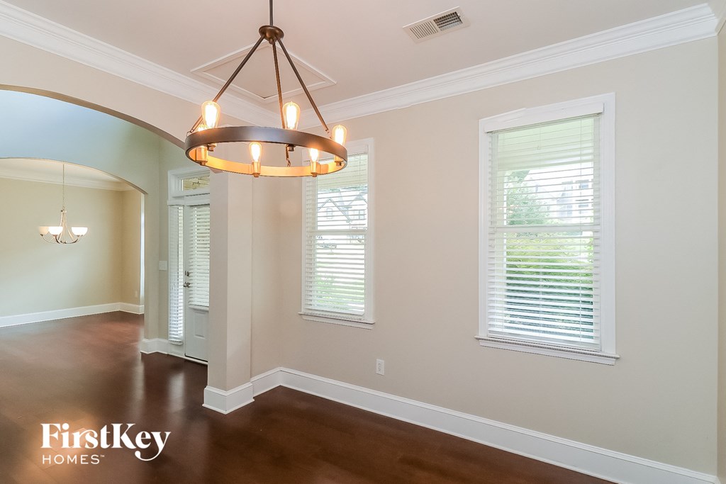 a dining room with a large window and a chandelier
