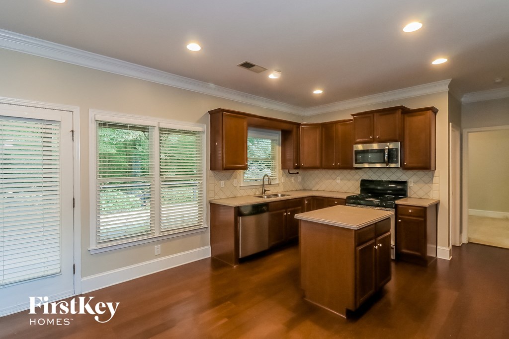 a kitchen with wooden cabinets and appliances and a large window