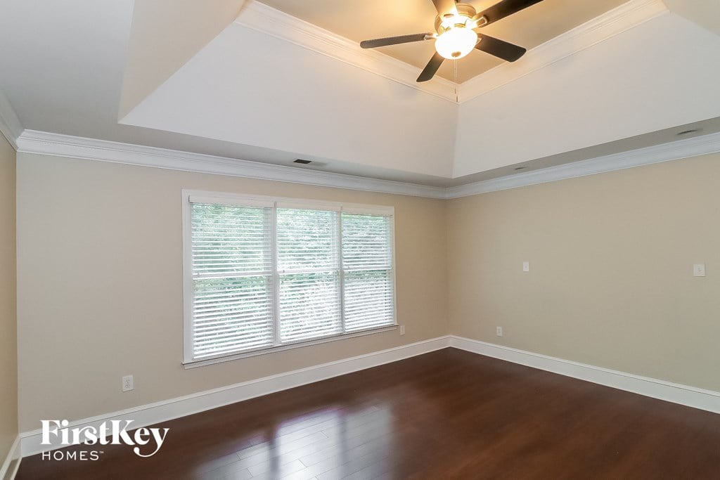 a living room with a ceiling fan and a large window