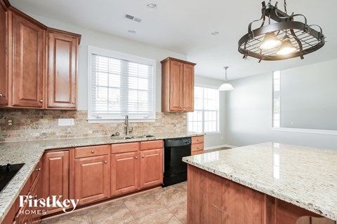 A kitchen with wooden cabinets and a granite countertop.