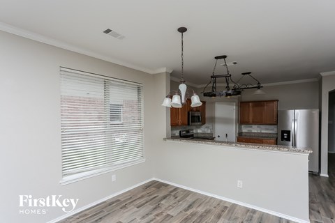 A kitchen with a white counter top and wooden floors.