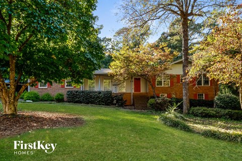 a red brick house with trees in front of it