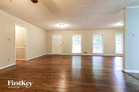 an empty living room with wood floors and white walls