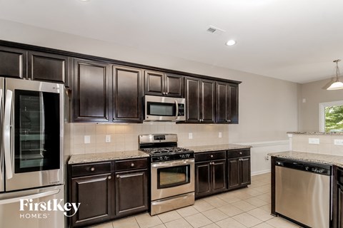 A kitchen with dark brown cabinets and stainless steel appliances.