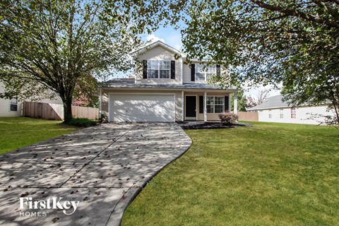 a driveway leading to a house with a garage door