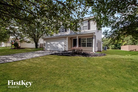 a white house with a lawn and a driveway