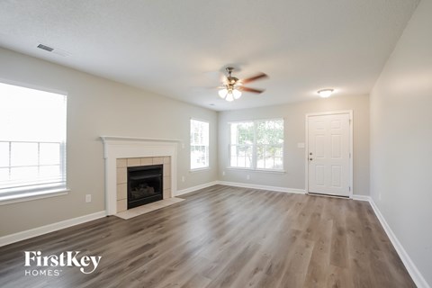 a living room with a fireplace and a ceiling fan