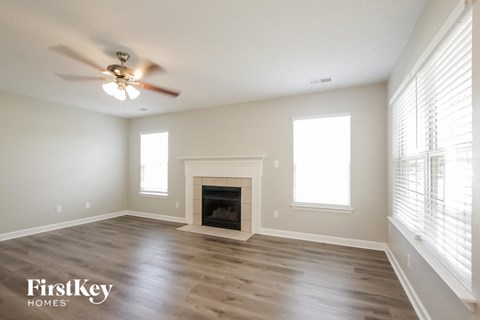a living room with a fireplace and a ceiling fan