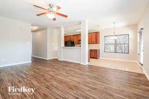 A spacious room with wooden flooring and a ceiling fan.