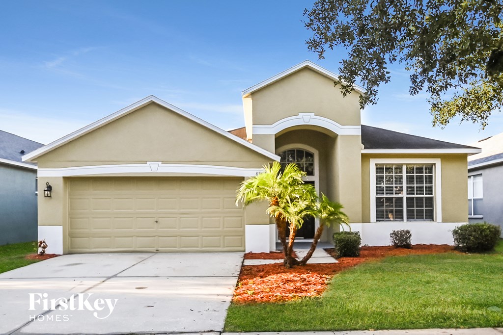 a beige house with a palm tree in front of it