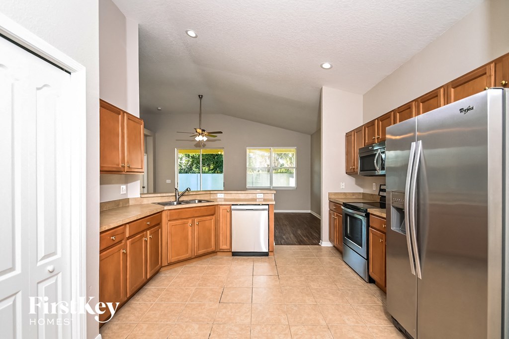 a kitchen with wooden cabinets and stainless steel appliances