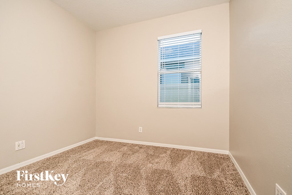 a spacious room with carpet and a window