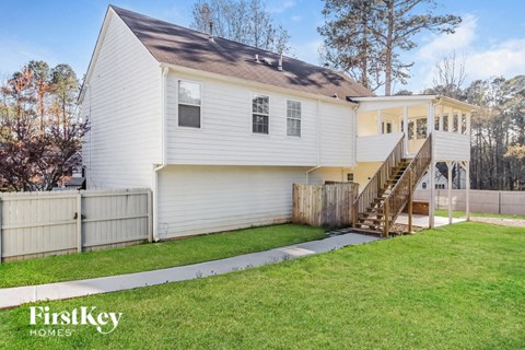 a white house with a yard and a wooden fence