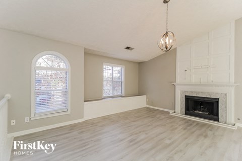 an empty living room with a fireplace and a window
