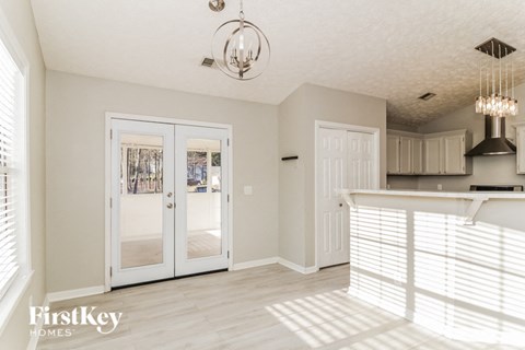 a kitchen and living room with white blinds on the doors and a white counter