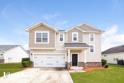 a beige house with a white garage door and a lawn