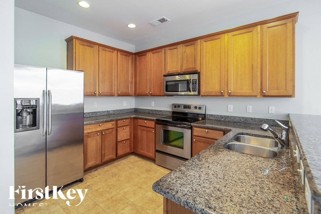 a kitchen with granite counter tops and wooden cabinets