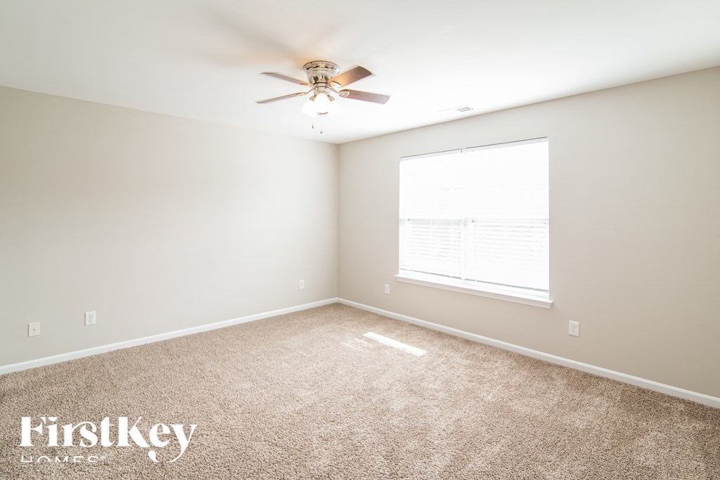 an empty room with a ceiling fan and a window