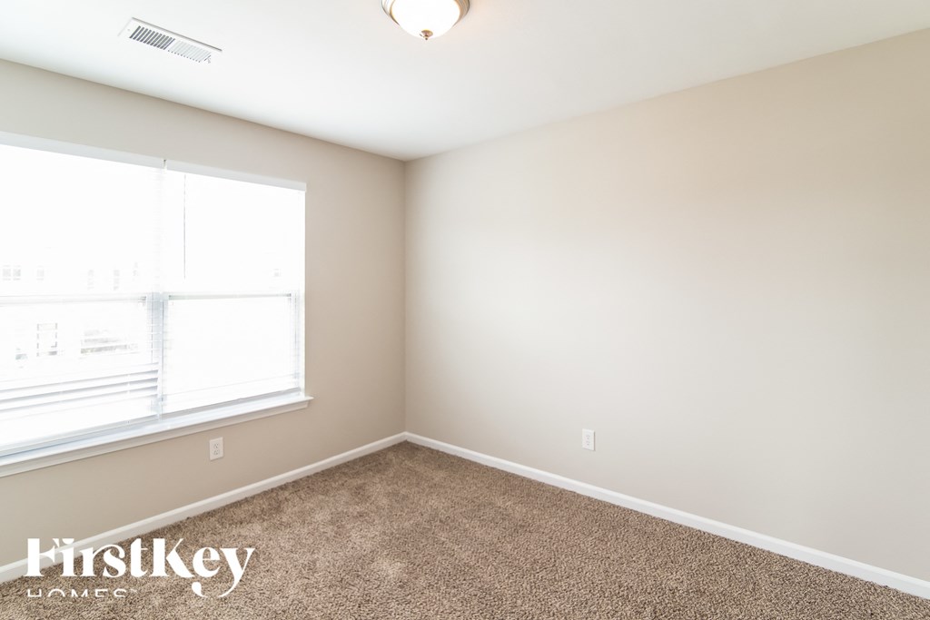 a bedroom with a carpeted floor and a large window