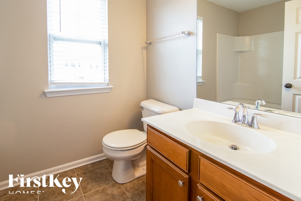 a bathroom with a toilet and a sink and a mirror