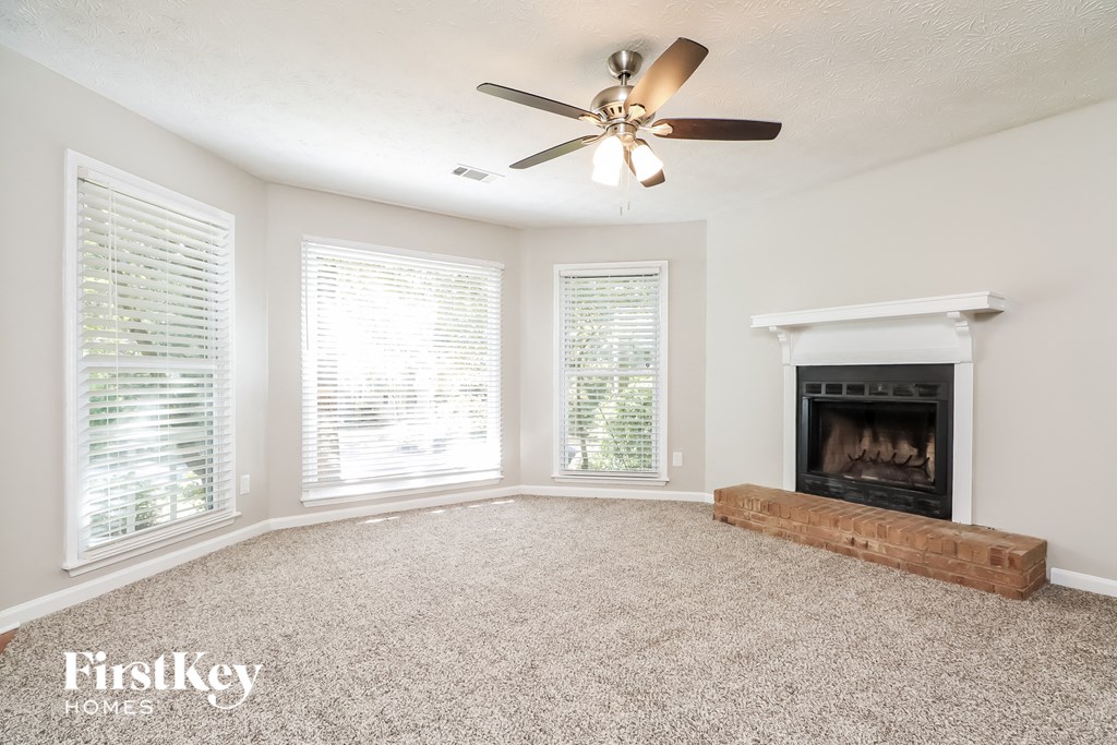 A room with a fireplace and a ceiling fan.