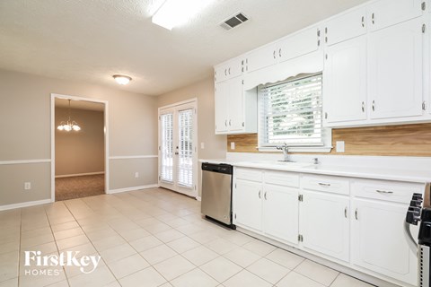 A kitchen with white cabinets and a dishwasher.