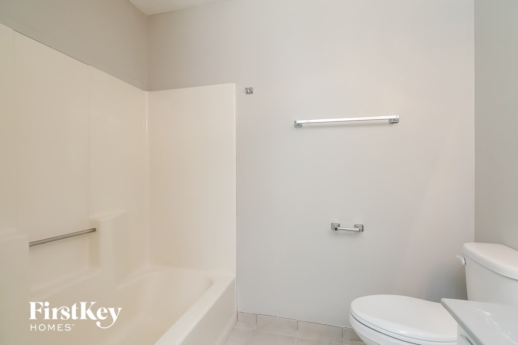 A white bathroom with a toilet, sink, and bathtub.