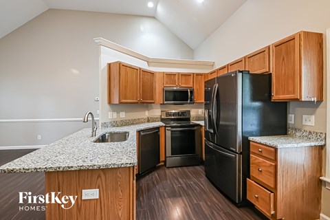 A kitchen with wooden cabinets and black appliances.