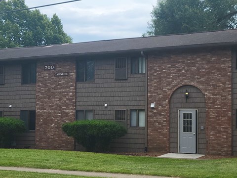 the front of a brick building with a blue door