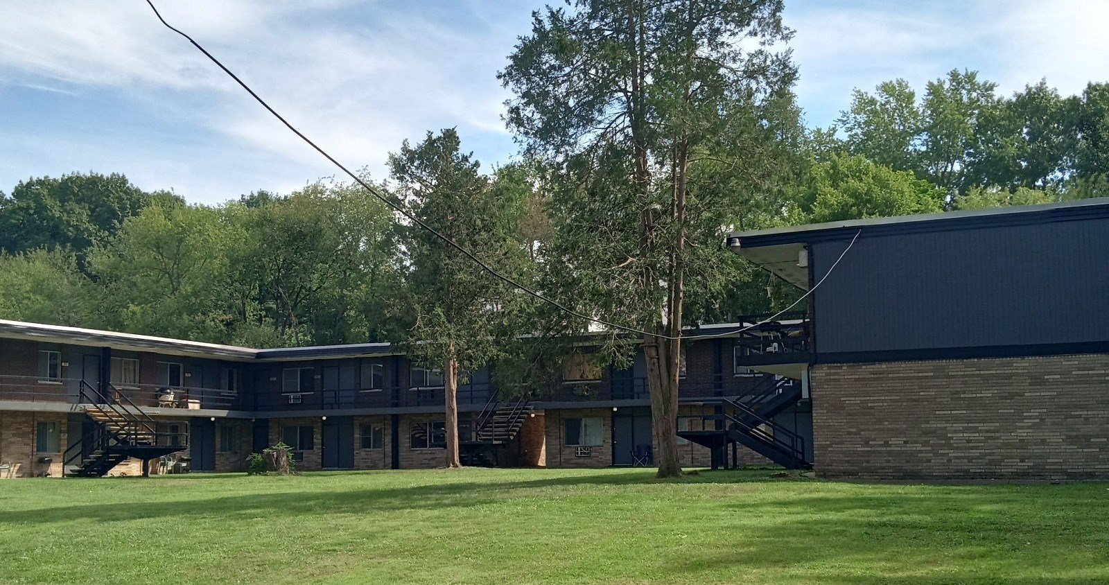 a row of houses with a grass yard and trees