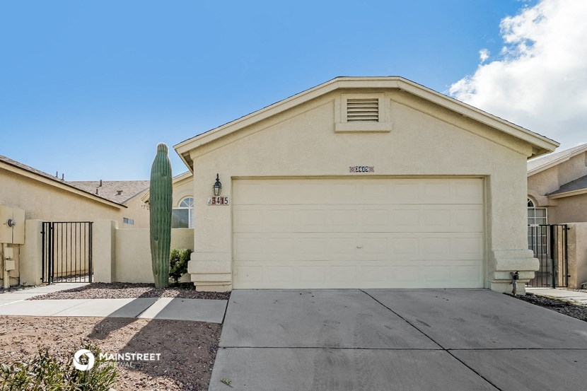 a white house with a white garage door and a cactus