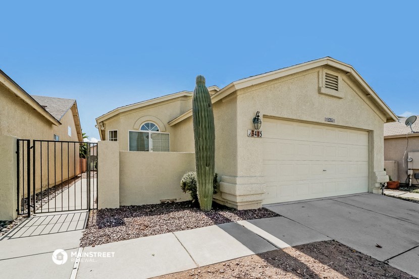a house with a cactus in front of a driveway